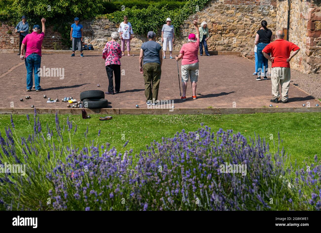 Haddington, East Lothian, Scozia, Regno Unito, 21 luglio 2021. Sessione di coaching U3A Pétanque SPA: Colin (Monty) e Margaret (Mags) Montgomery, entrambi i pullman SPA (Scottish Pétanque Association) offrono una lezione al locale club di Pétanque dell'Università della 3a Età in uno dei giorni più caldi dell'anno nei giardini panoramici di Lady Kitty's Garden. Pétanque è una forma di boules, giocato con regole leggermente diverse Foto Stock