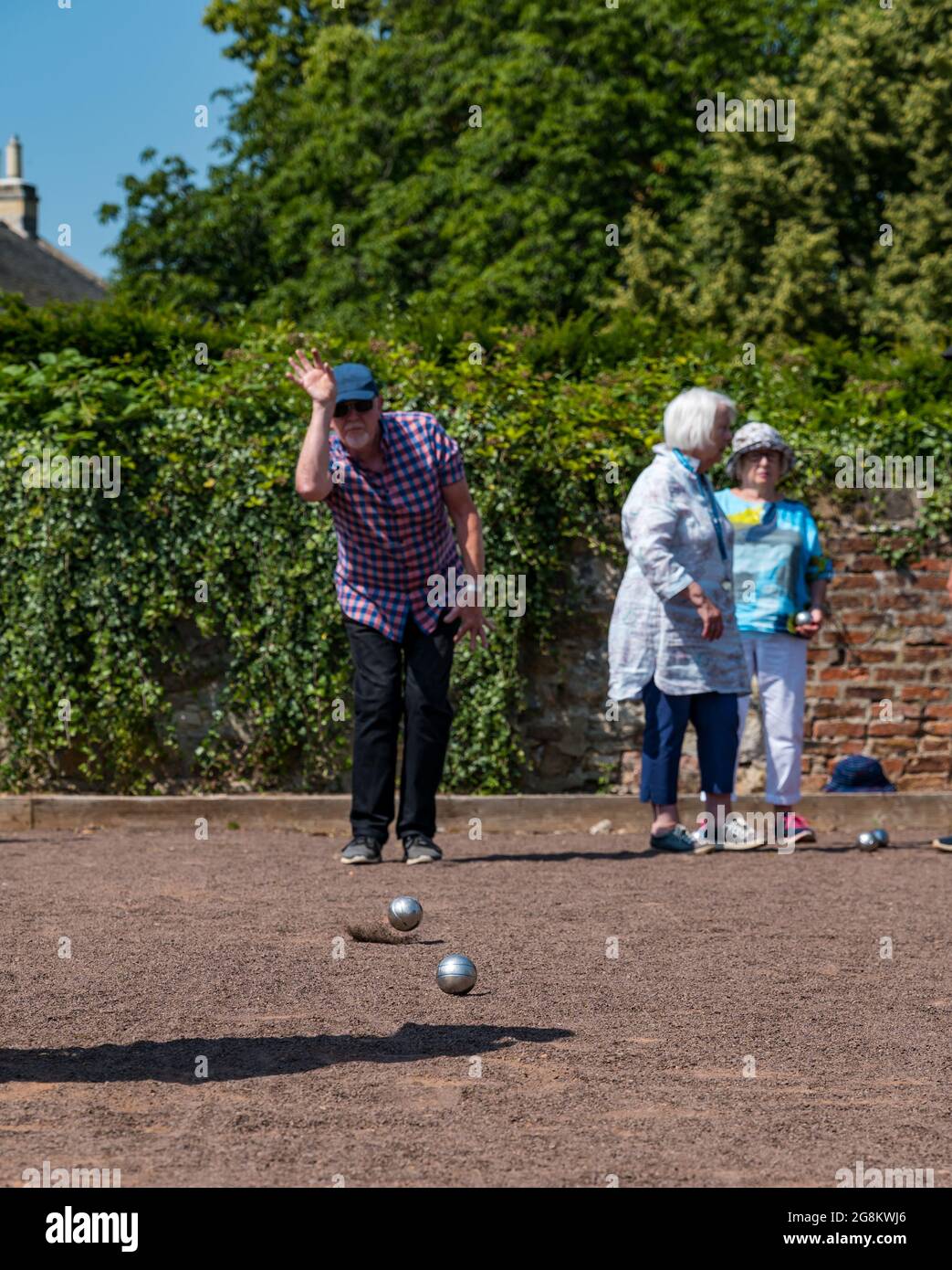 Haddington, East Lothian, Scozia, Regno Unito, 21 luglio 2021. Sessione di coaching U3A Pétanque SPA: Colin (Monty) e Margaret (Mags) Montgomery, entrambi i pullman SPA (Scottish Pétanque Association) offrono una lezione al locale club di Pétanque dell'Università della 3a Età in uno dei giorni più caldi dell'anno nei giardini panoramici di Lady Kitty's Garden. Pétanque è una forma di boules, giocato con regole leggermente diverse Foto Stock