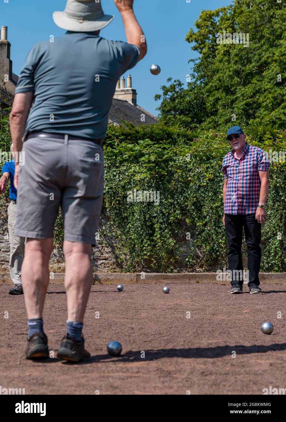 Haddington, East Lothian, Scozia, Regno Unito, 21 luglio 2021. Sessione di coaching U3A Pétanque SPA: Colin (Monty) e Margaret (Mags) Montgomery, entrambi i pullman SPA (Scottish Pétanque Association) offrono una lezione al locale club di Pétanque dell'Università della 3a Età in uno dei giorni più caldi dell'anno nei giardini panoramici di Lady Kitty's Garden. Pétanque è una forma di boules, giocato con regole leggermente diverse Foto Stock