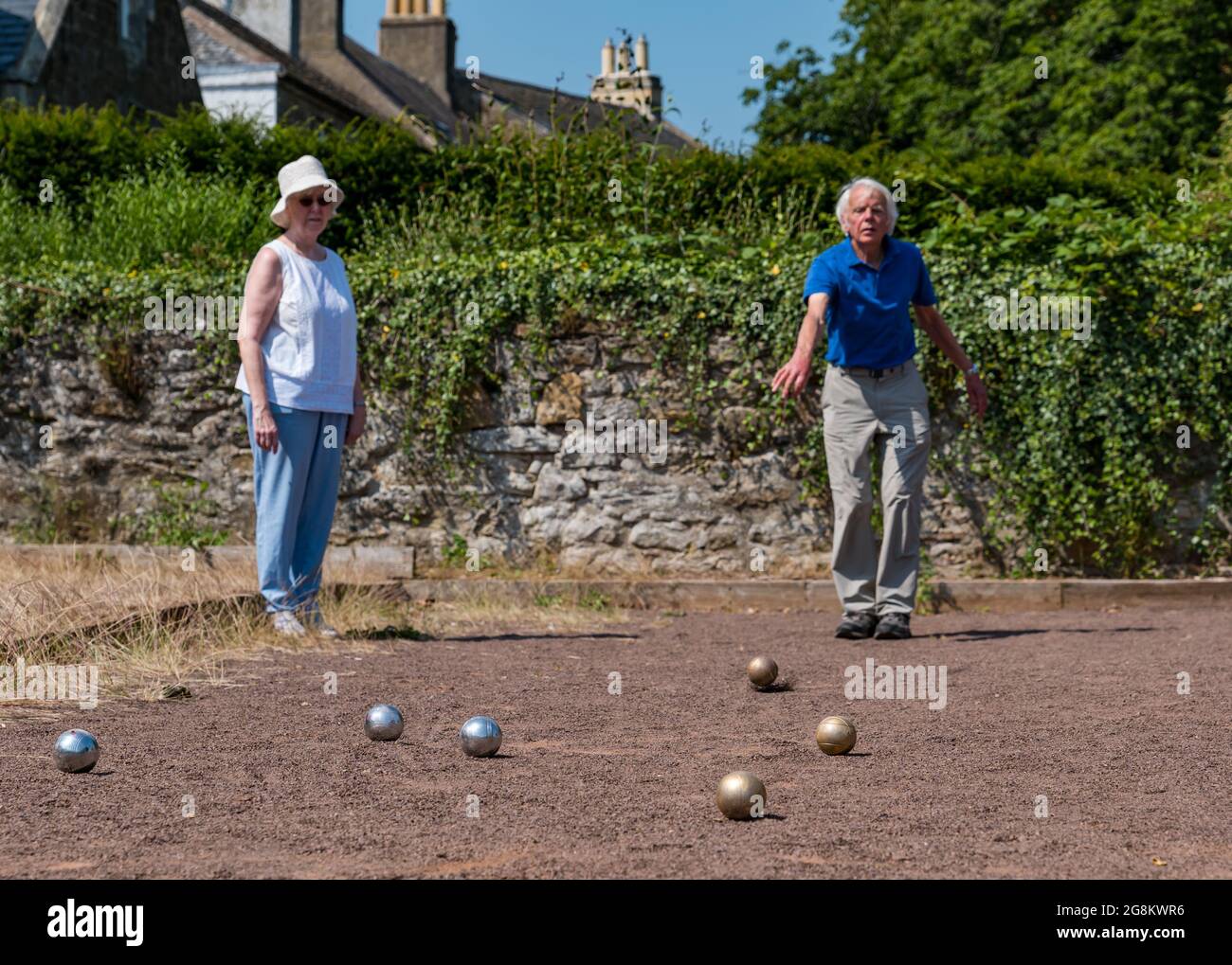 Haddington, East Lothian, Scozia, Regno Unito, 21 luglio 2021. Sessione di coaching U3A Pétanque SPA: Colin (Monty) e Margaret (Mags) Montgomery, entrambi i pullman SPA (Scottish Pétanque Association) offrono una lezione al locale club di Pétanque dell'Università della 3a Età in uno dei giorni più caldi dell'anno nei giardini panoramici di Lady Kitty's Garden. Pétanque è una forma di boules, giocato con regole leggermente diverse Foto Stock