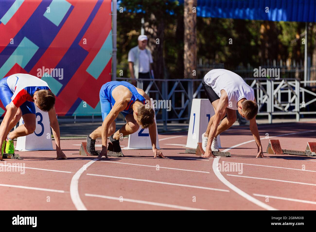 atleti di sesso maschile alle posizioni di partenza della pista e della gara  di campo Foto stock - Alamy