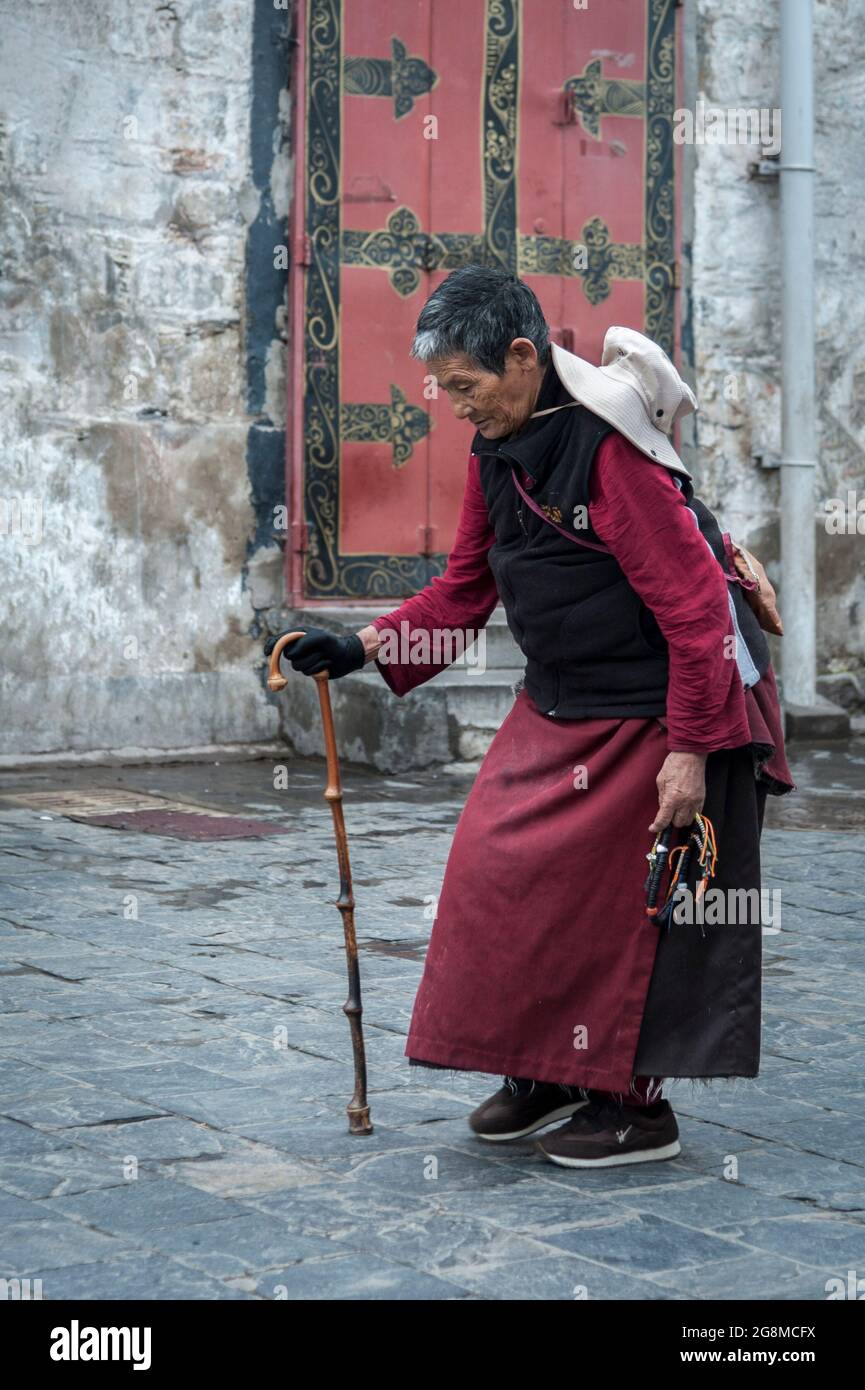 Pellegrino tibetano non identificato che esegue il Barkhor Kora (camminando in senso orario intorno al Tempio di Jokhang) Foto Stock