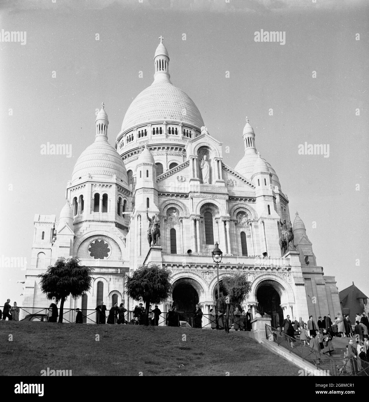 Anni '50, immagine storica della Basilica del Sacro cuore di Parigi, più comunemente conosciuta semplicemente come Sacre-Coeur, una chiesa cattolica romana costruita sulla collina di Montmartre, Parigi, Francia. Questo monumento iconico è stato consacrato nel 1919 ed è il secondo edificio religioso più visitato di Parigi. Foto Stock