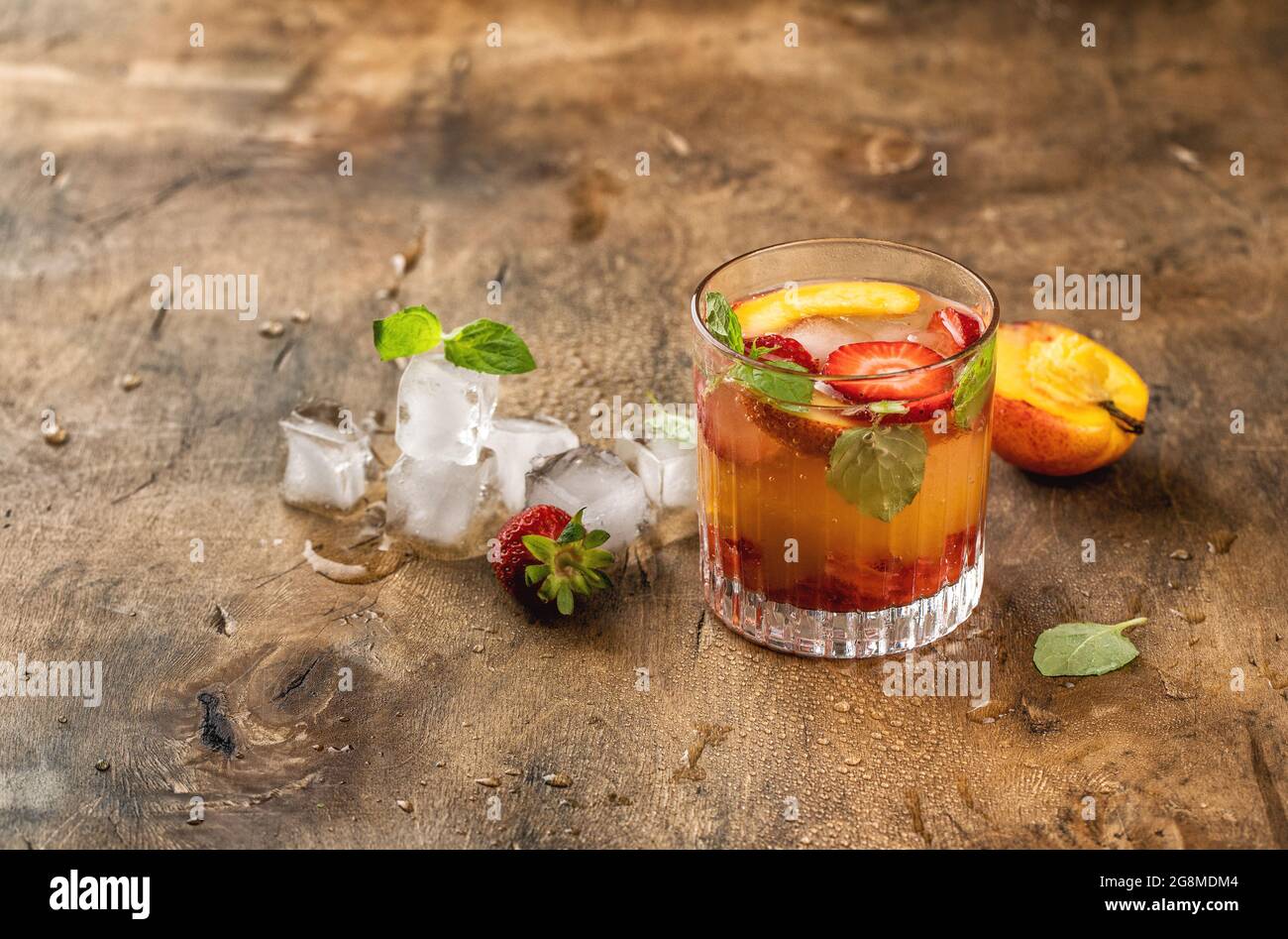 Limonata di frutta estiva. Bevanda fredda con pesca, fragola, ghiaccio, foglie di menta Foto Stock