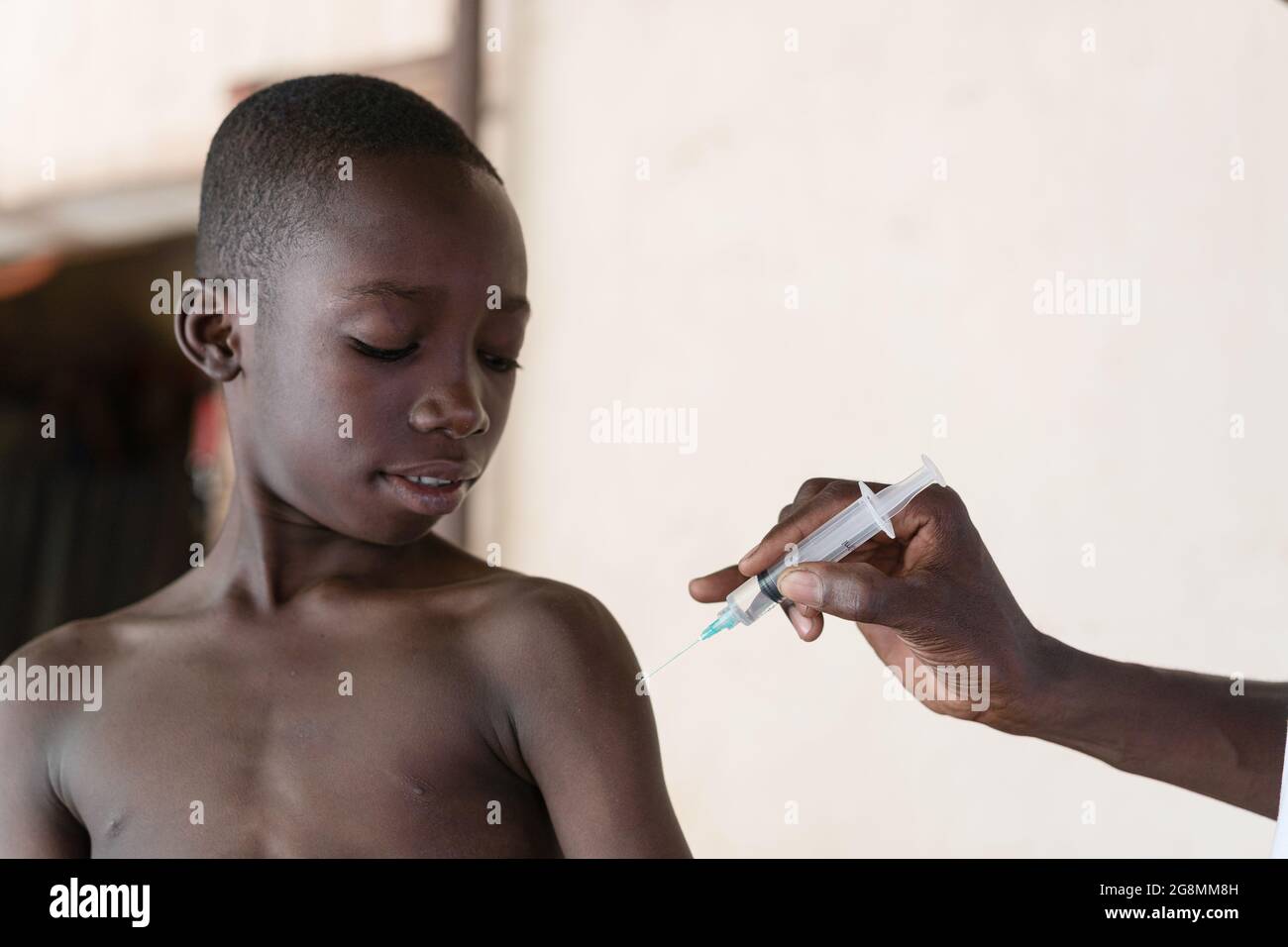 Questa è un'immagine di un giovane e adorabile bambino africano nero che sorride i momenti prima di ottenere il suo primo vaccino. Foto Stock