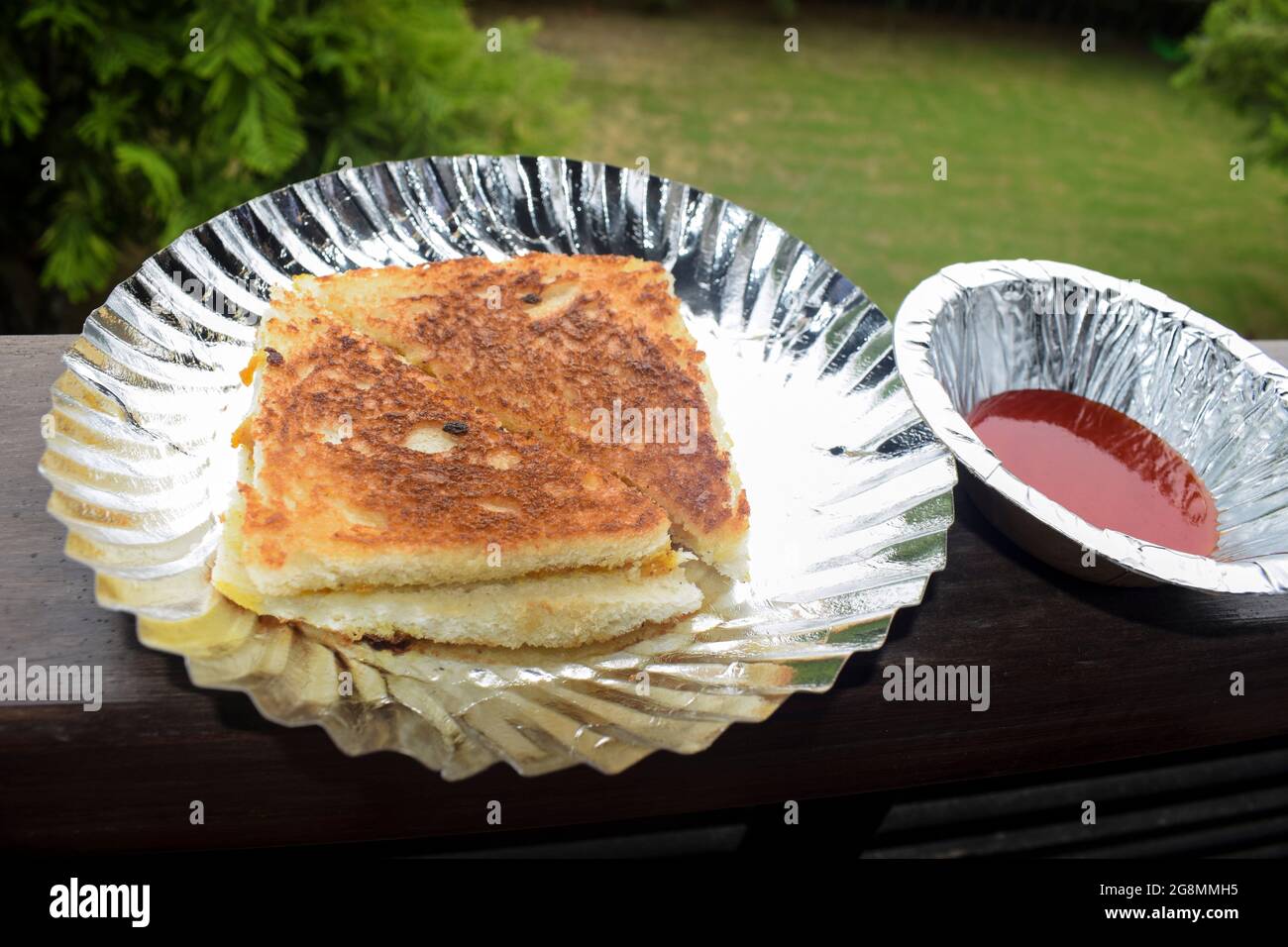 Sandwich ripieni di patate alla griglia in stile indiano. Alo sabji ripieno di curry in pausa e alla griglia. Servito con ketchup di pomodoro a colazione e tè sna Foto Stock