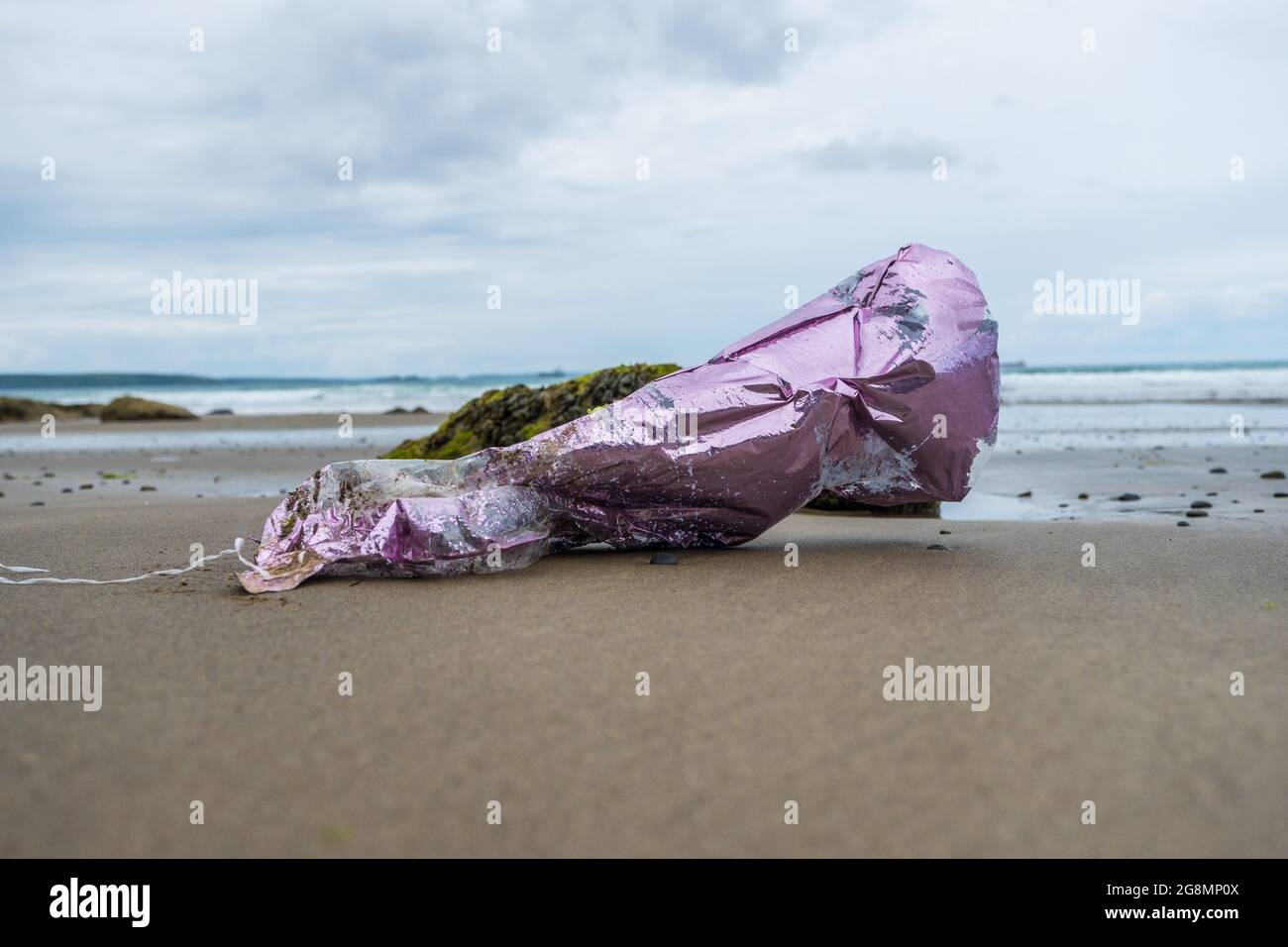Festa mongolfiera litterando una spiaggia gallese Foto Stock