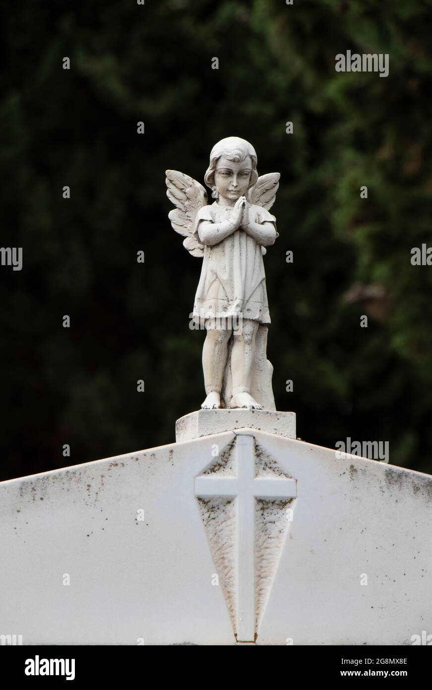 Piccola statua di una bambina d'angelo con le ali alla lapide presso il vecchio cimitero in Dalmazia, Croazia, primo piano Foto Stock