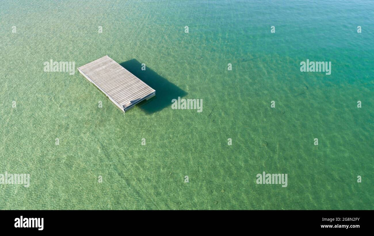 acqua calma e un molo di legno su cui riposarsi Foto Stock