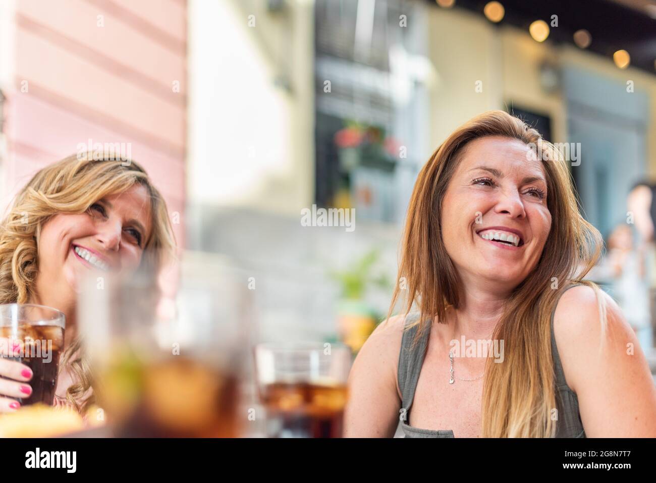 Donne adulte di mezza età in un bar che beve e chiacchierando Foto Stock