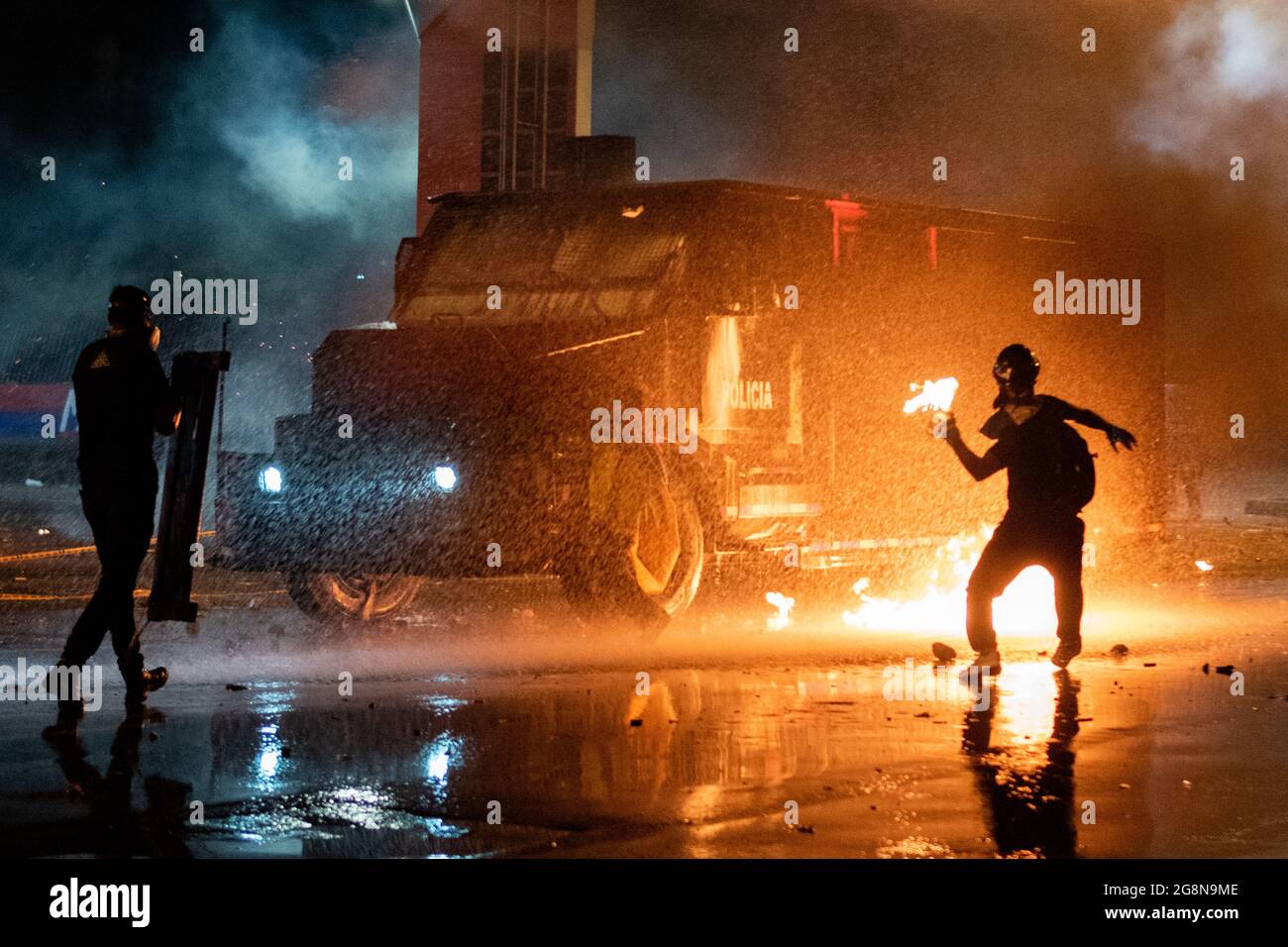 Un dimostratore lancia una bomba molotov su un camion corazzato durante una nuova giornata di proteste anti-governative durante la celebrazione del 211 dell'indipendenza della Colombia dalla spagna, proteste sollevate in scontri in varie città dopo l'intervento della polizia maledetta della Colombia ESMAD, a Medellin, Colombia, il 20 luglio 2021. Foto Stock