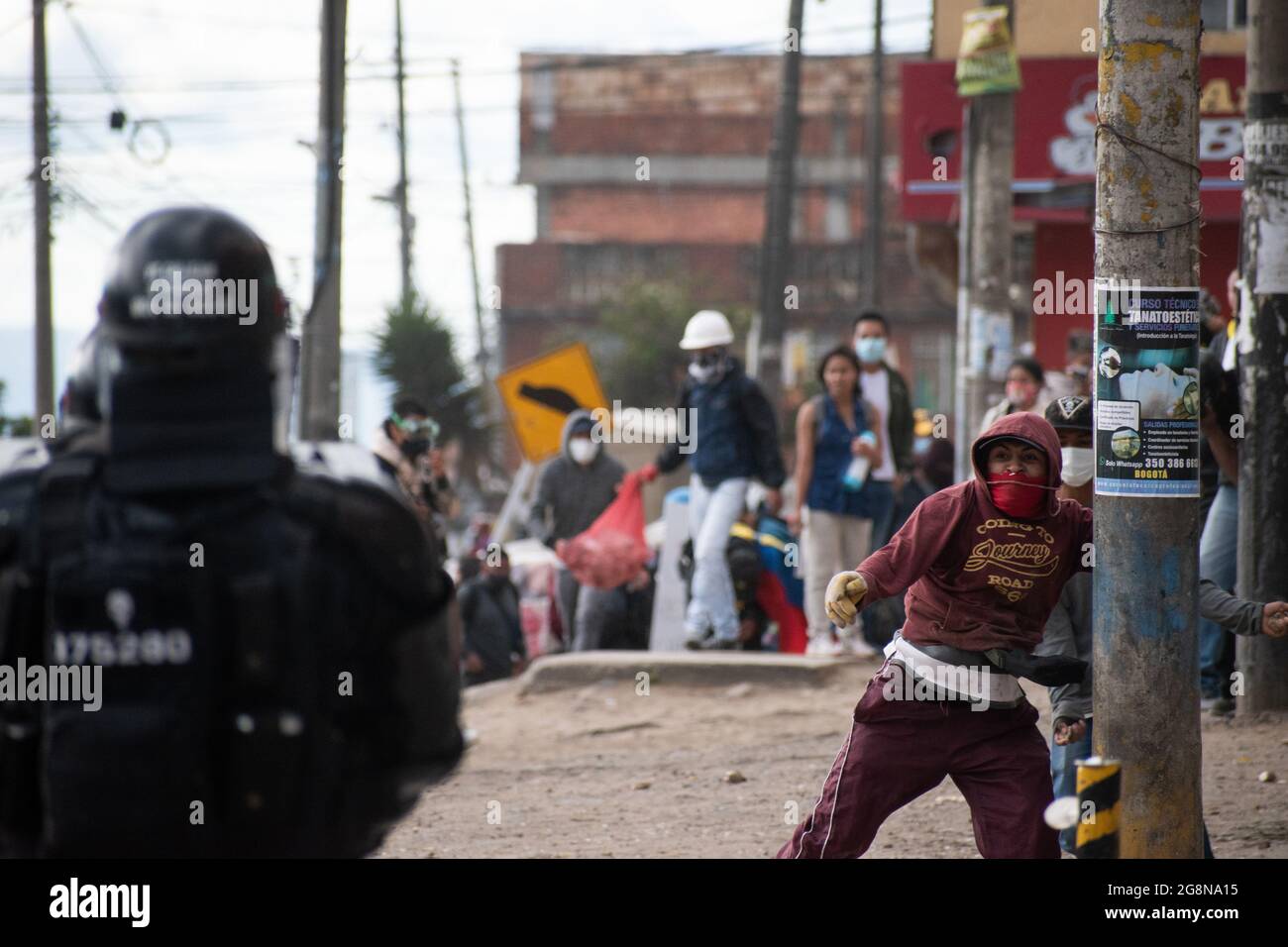 Un dimostratore getta rocce e depree alla polizia durante una nuova giornata di proteste anti-governative durante la celebrazione del 211 dell'indipendenza della Colombia dalla spagna, proteste sollevate in scontri in varie città dopo l'intervento della polizia malata della Colombia ESMAD, a Bogotà, Colombia, il 20 luglio 2021. Foto Stock