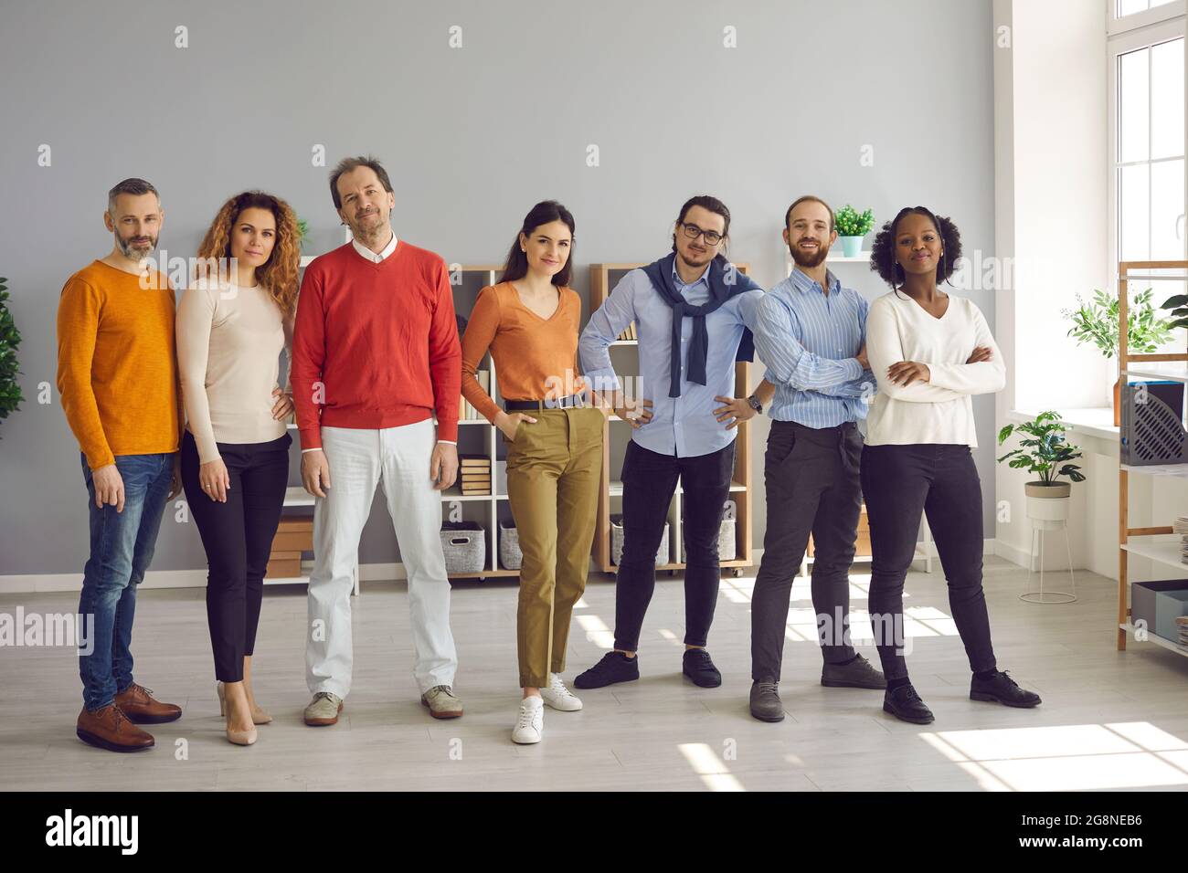 Multirazziale diversi giovani adulti in piedi insieme in un ufficio luminoso Foto Stock
