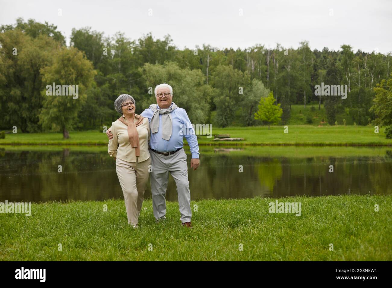 Una coppia anziana in abiti informali cammina all'aperto Foto Stock