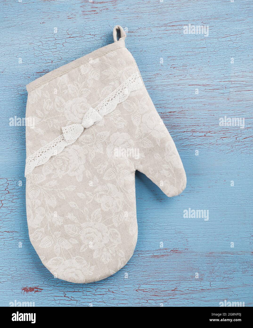 Flat rustico still life, guanto da cucina tessile su sfondo di legno blu rosso in stile country Foto Stock