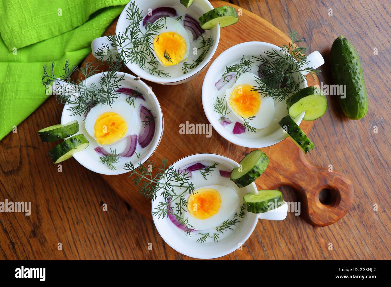 Zuppa fredda con cetrioli, yogurt, uova ed erbe fresche sul tavolo rustico in legno Foto Stock