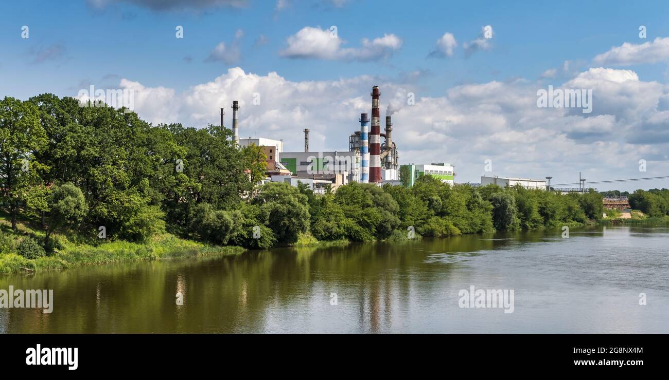 tubi di legno impresa segheria pianta vicino fiume. Concetto di inquinamento dell'aria. Paesaggio industriale inquinamento ambientale spreco di energia termica p Foto Stock