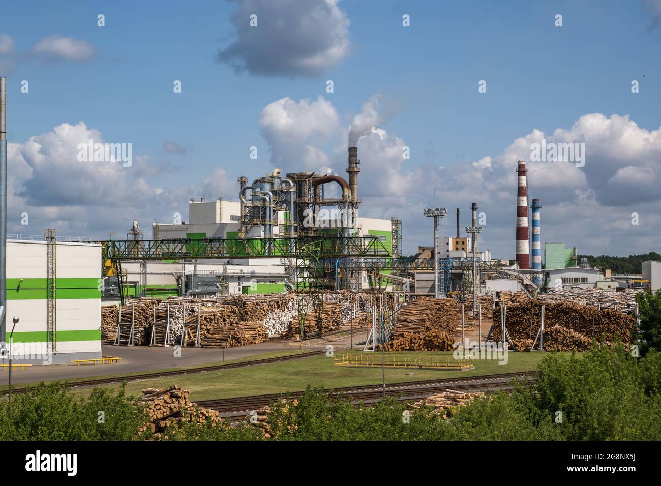 tubi di legno impresa segheria pianta vicino fiume. Concetto di inquinamento dell'aria. Paesaggio industriale inquinamento ambientale spreco di energia termica p Foto Stock