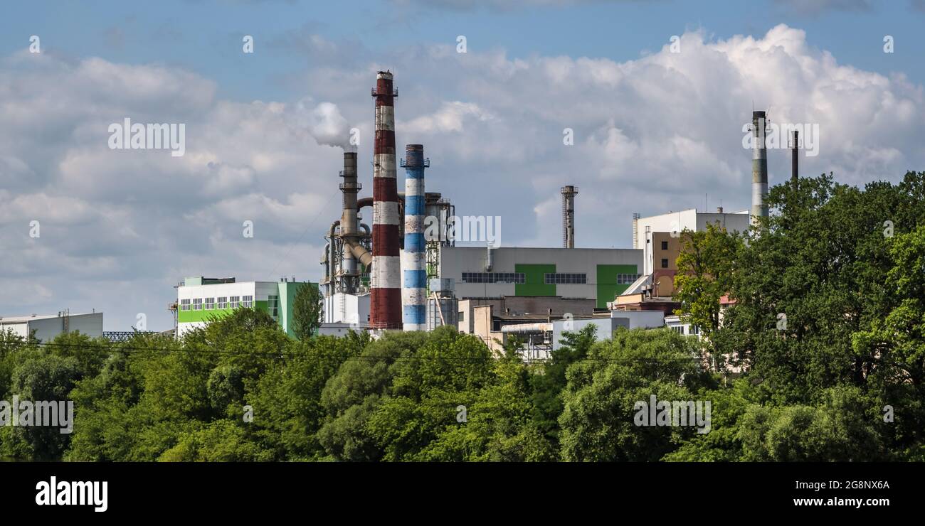 tubi di legno impresa segheria pianta vicino fiume. Concetto di inquinamento dell'aria. Paesaggio industriale inquinamento ambientale spreco di energia termica p Foto Stock