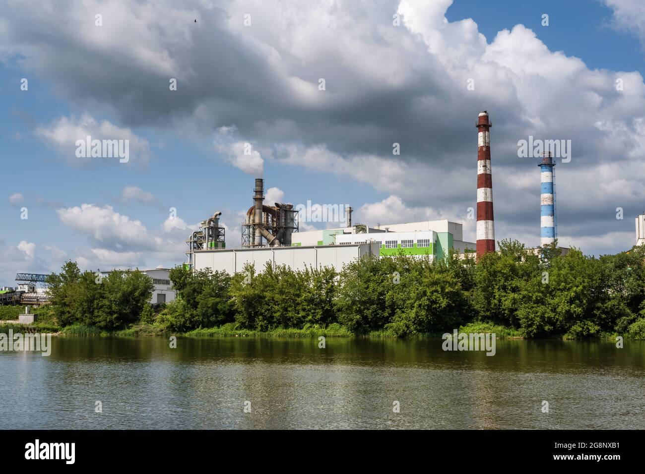 tubi di legno impresa segheria pianta vicino fiume. Concetto di inquinamento dell'aria. Paesaggio industriale inquinamento ambientale spreco di energia termica p Foto Stock
