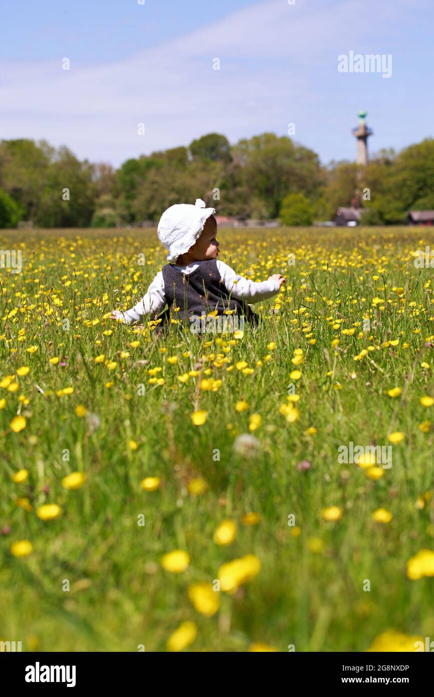 bambina femmina in piedi in un campo di buttercup con le braccia allungate Foto Stock