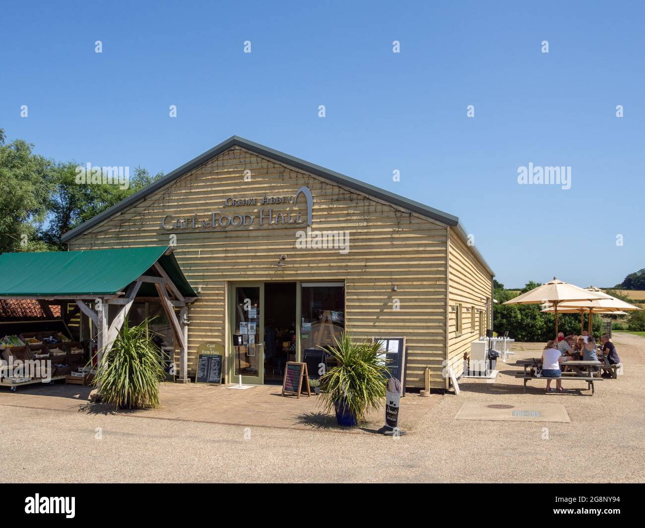 Creake Abbey, caffetteria e sala ristorazione, situata nei terreni di un'abbazia del XIII secolo in rovina, North Creake, Norfolk, Regno Unito; i visitatori si divertono a mangiare all'aperto Foto Stock