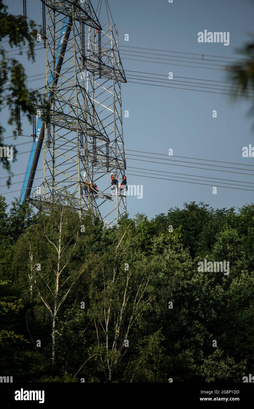 Auf einem Feld zwischen Kaarst und Düsseldorf bauen Mitarbeiter der Firma SPIE Leitungsbau einen Elektrizitätsmast auf. Wie Playmobil-Männchen sehen d Foto Stock