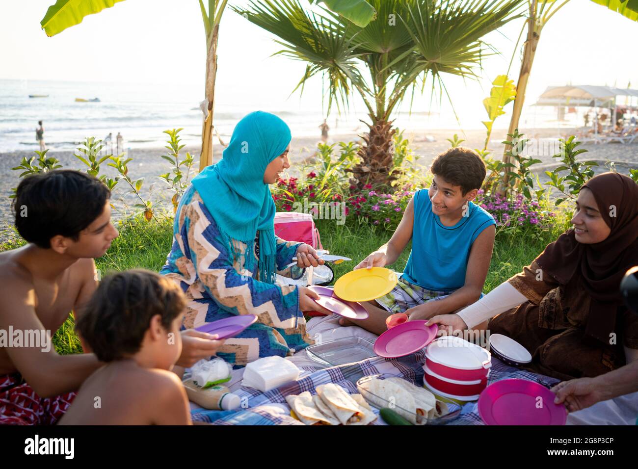 Buona famiglia godendo pic-nic sulla spiaggia vicino al mare Foto Stock