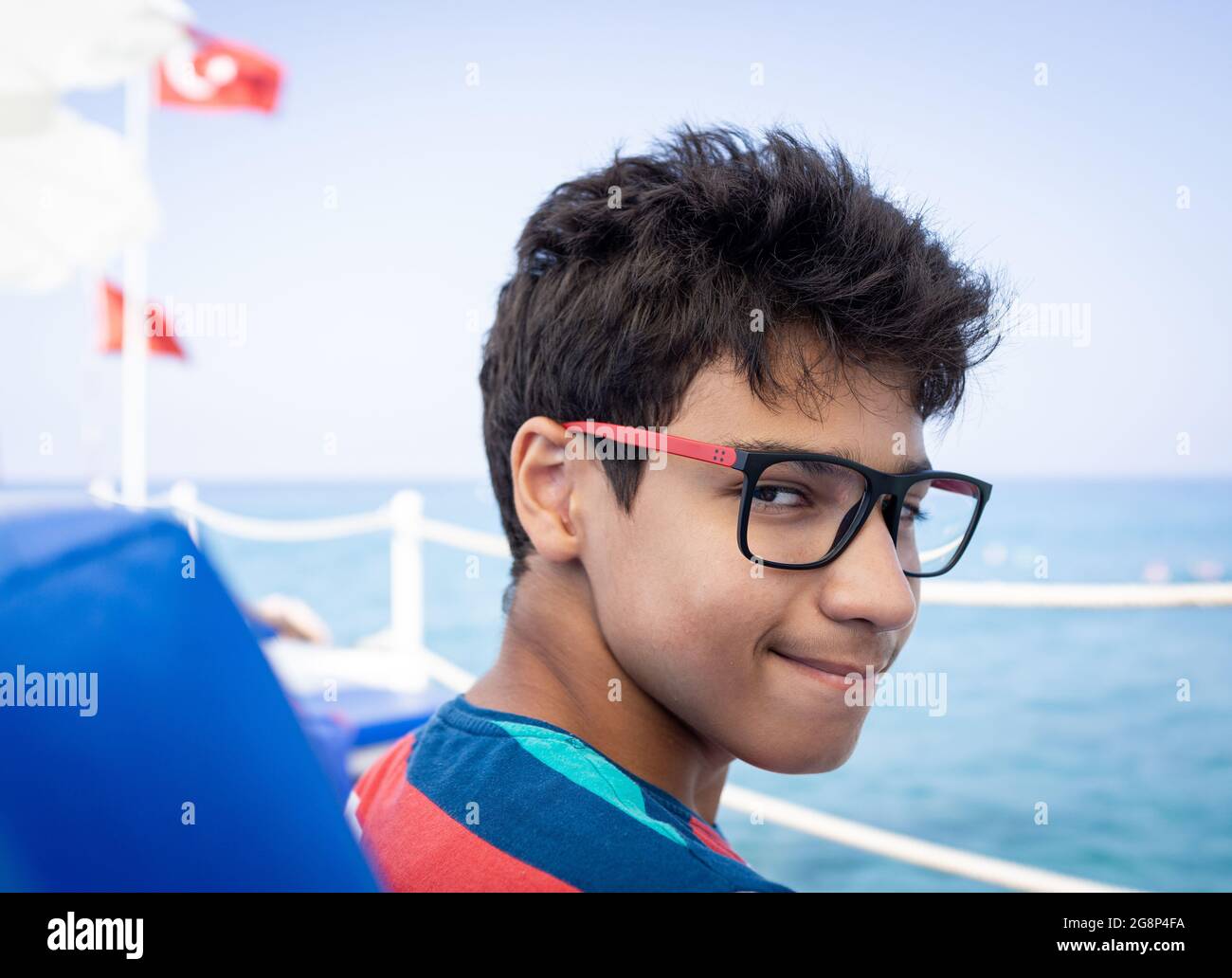 Ragazzo adolescente seduto sulla sedia del molo e godendosi Foto Stock