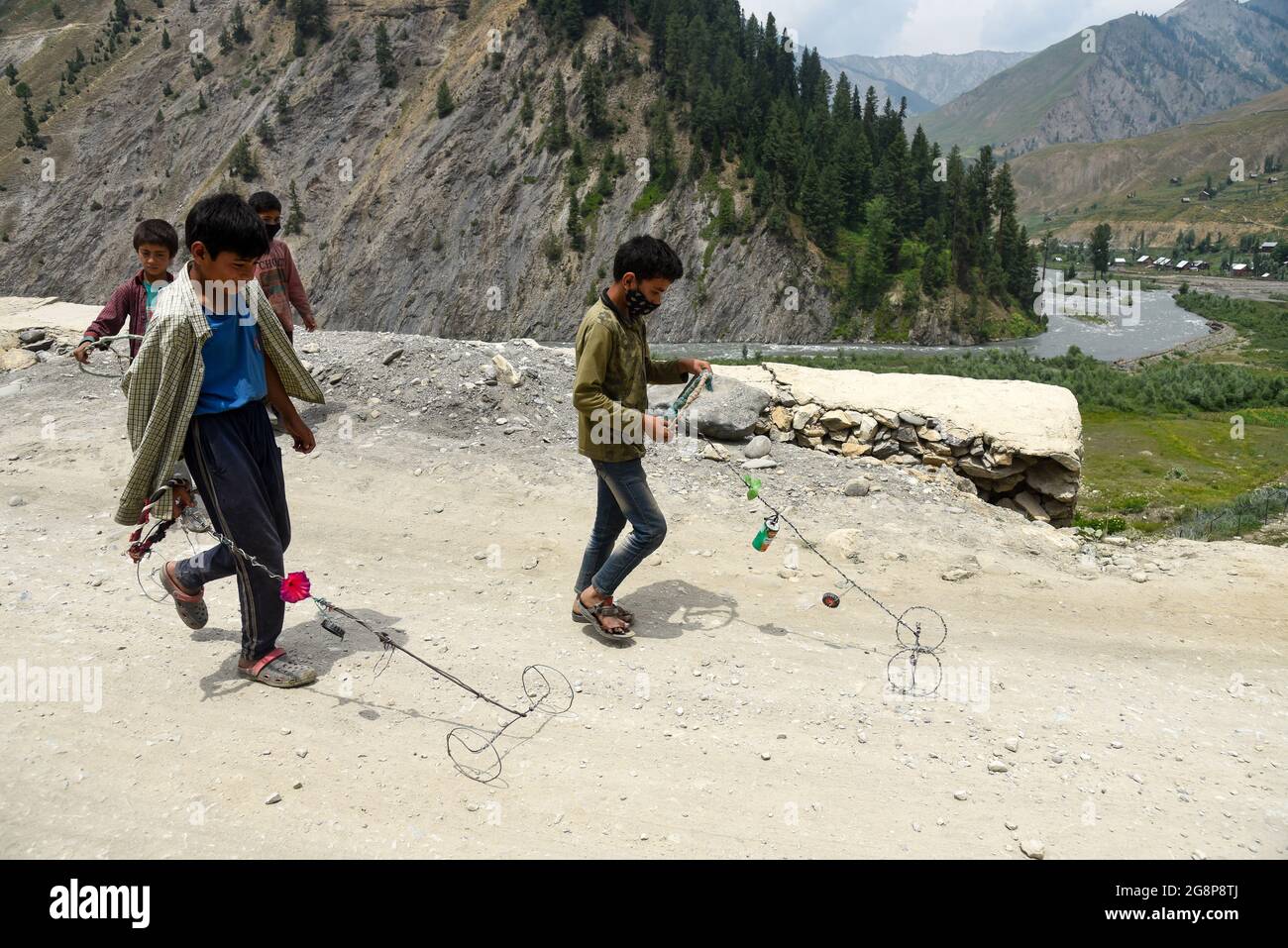 Bandipora, India. 22 luglio 2021. I bambini giocano vicino alla recinzione di confine a Tulail, Gurez.Gurez si trova lungo la LOC (linea di controllo) nella parte settentrionale del Kashmir. Le persone a Gurez sono i Dard-Shins con la loro ascendenza che vivono a Gilgit in Pakistan. Le caratteristiche e l'abbigliamento del Dard sono simili al Kashmiris. Credit: SOPA Images Limited/Alamy Live News Foto Stock