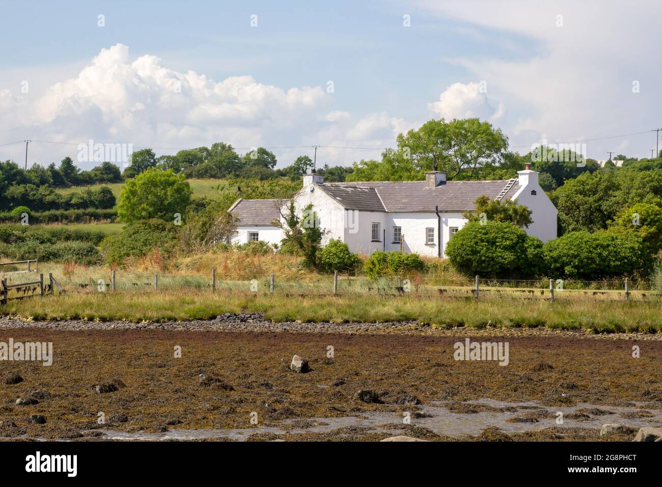21 luglio 2021 UN piccolo bungalow bianco con il proprio molo di legno si trova sul bordo dell'acqua vicino a Gibbs Island su Strangford Lough nella contea in basso a nord i Foto Stock