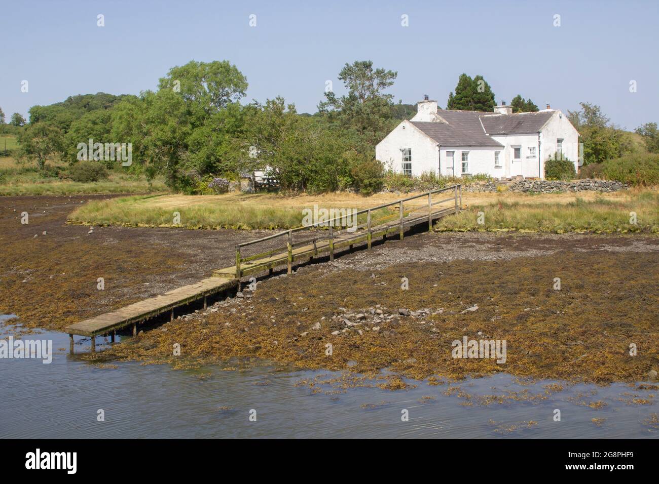 21 luglio 2021 UN piccolo bungalow bianco con il proprio molo di legno si trova sul bordo dell'acqua vicino a Gibbs Island su Strangford Lough nella contea in basso a nord i Foto Stock