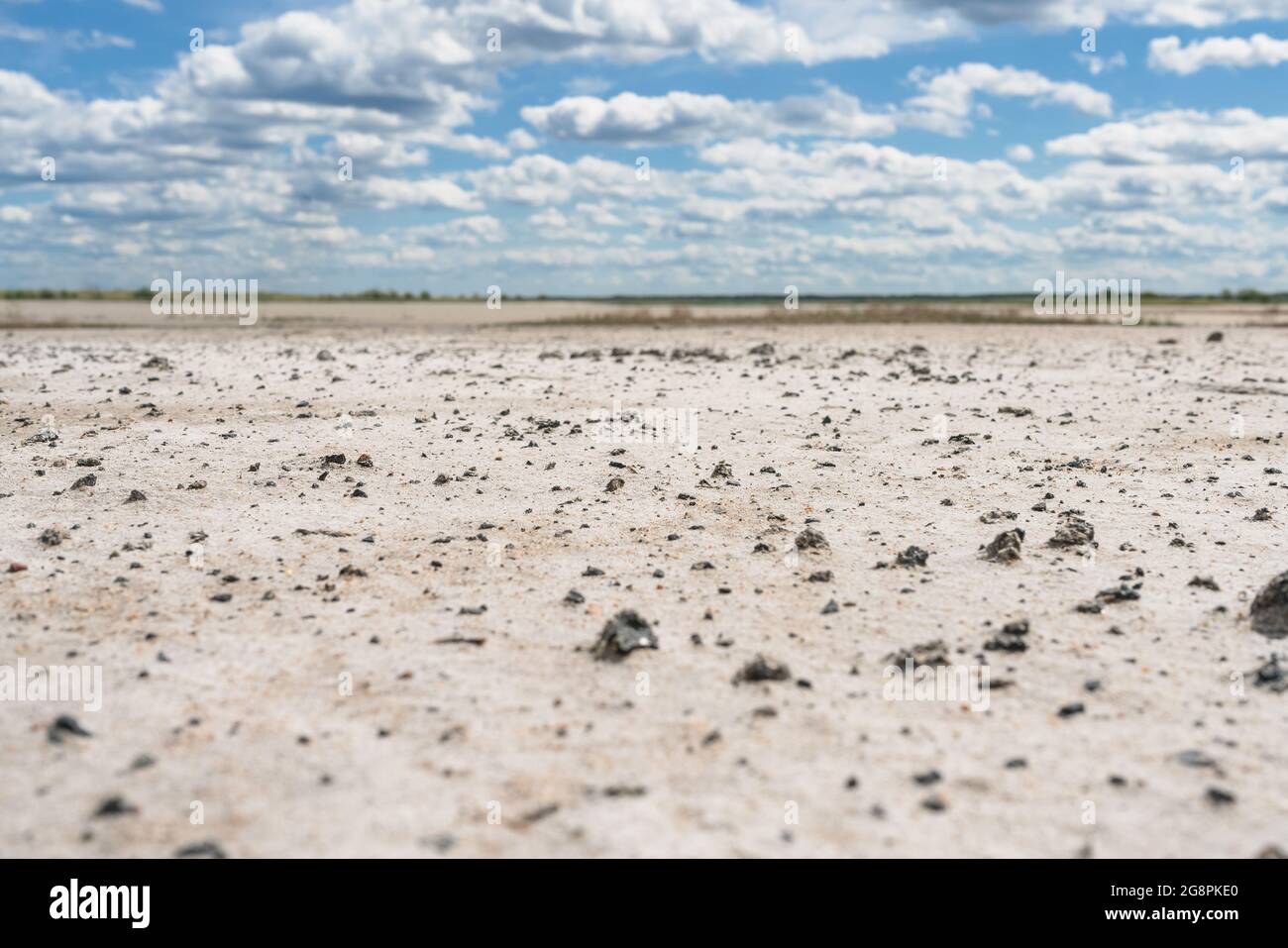 palude di sale con piccole pietre nere e cielo nuvoloso su di esso vista ad angolo basso Foto Stock