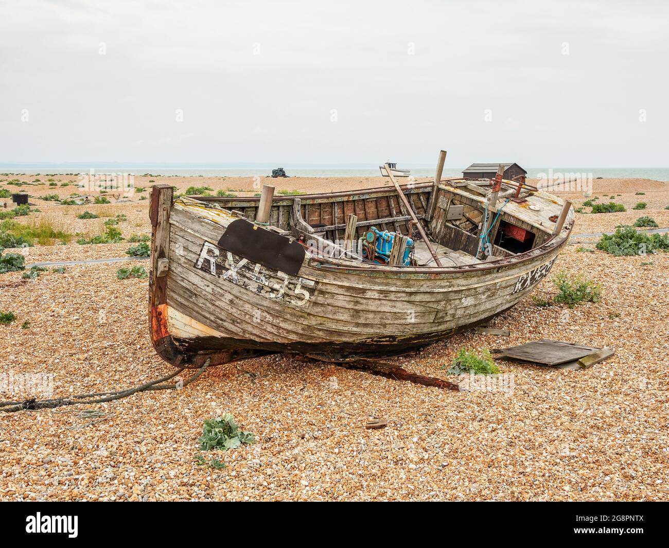 Dungeness spiaggia con derelict barca da pesca Kent Foto Stock