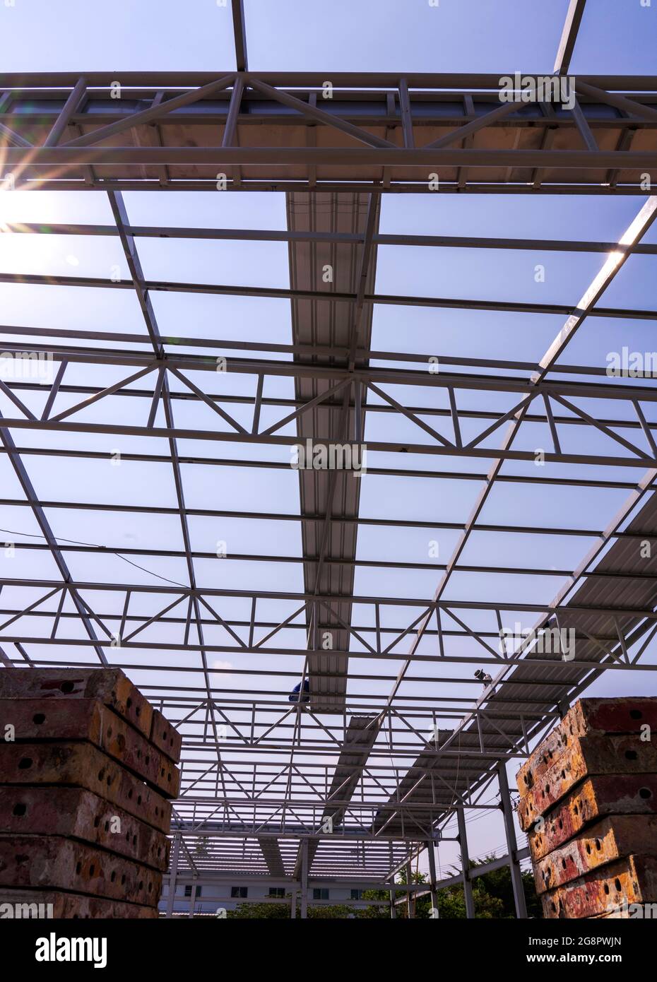 I lavoratori edili stanno installando la lamiera per tetti su truss in acciaio leggero e costruzione di telai. Foto Stock