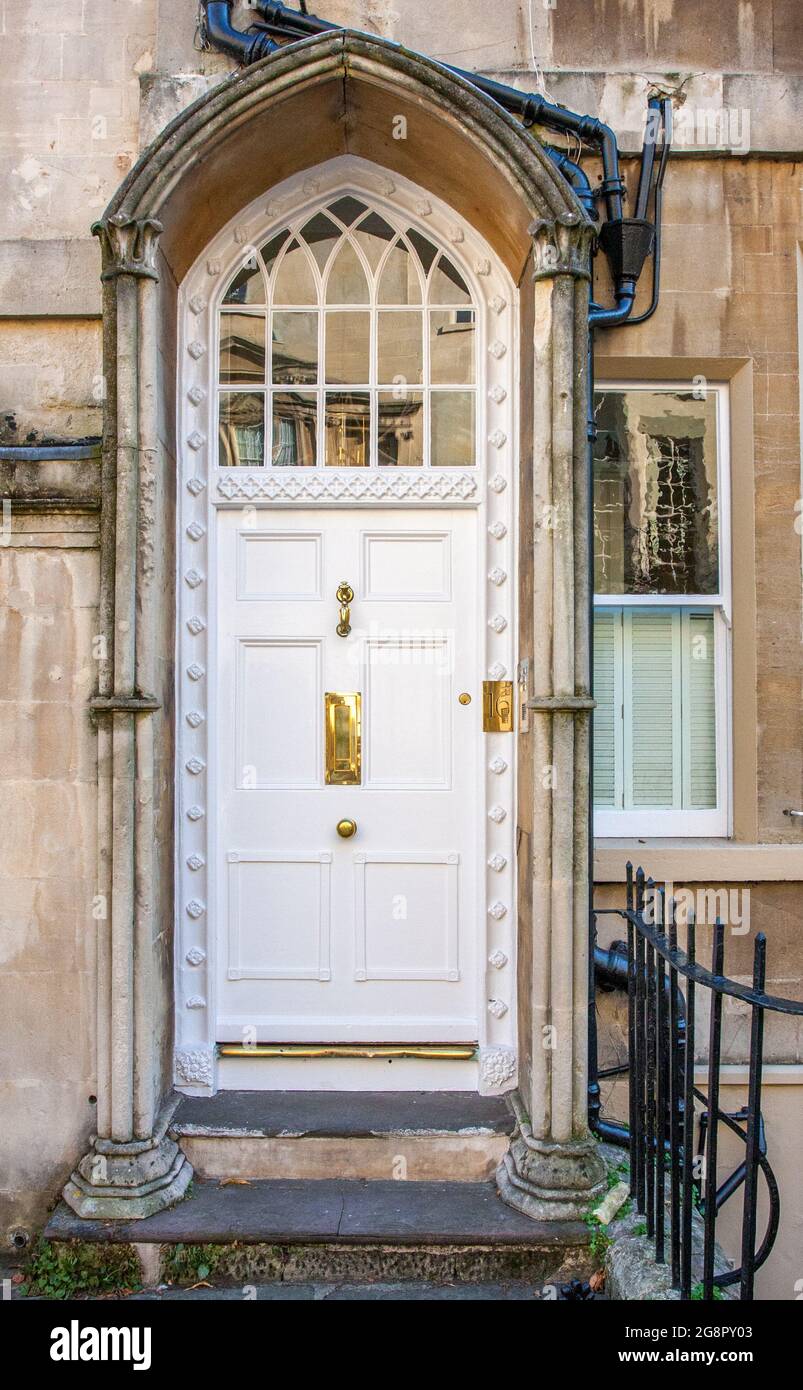 Elegante porta d'ingresso di una casa georgiana a Bath UK con portico in pietra intagliata ed eleganti finestre gotiche Foto Stock