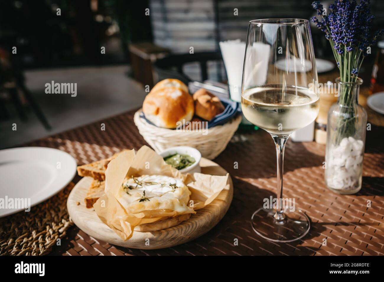 Bicchiere di vino bianco freddo e formaggio camembert al forno Foto Stock