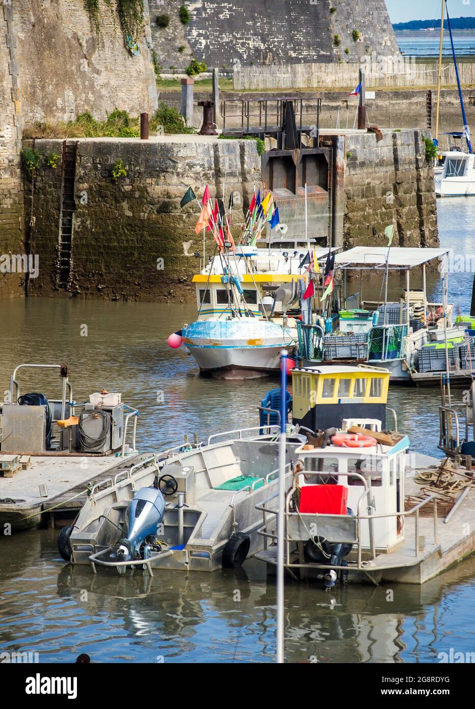 Barche da pesca e ostriche contadini a bassa marea nel porto di Chateau d'Oléron Foto Stock