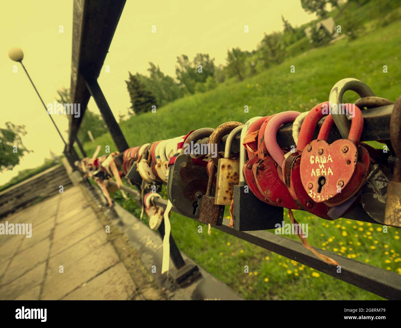 Ponte d'amore con lucchetti multicolore degli sposi novelli. Lucchetti con chiavi gettate nel fiume, simbolo di fedeltà indistruttibile ed eterna Foto Stock