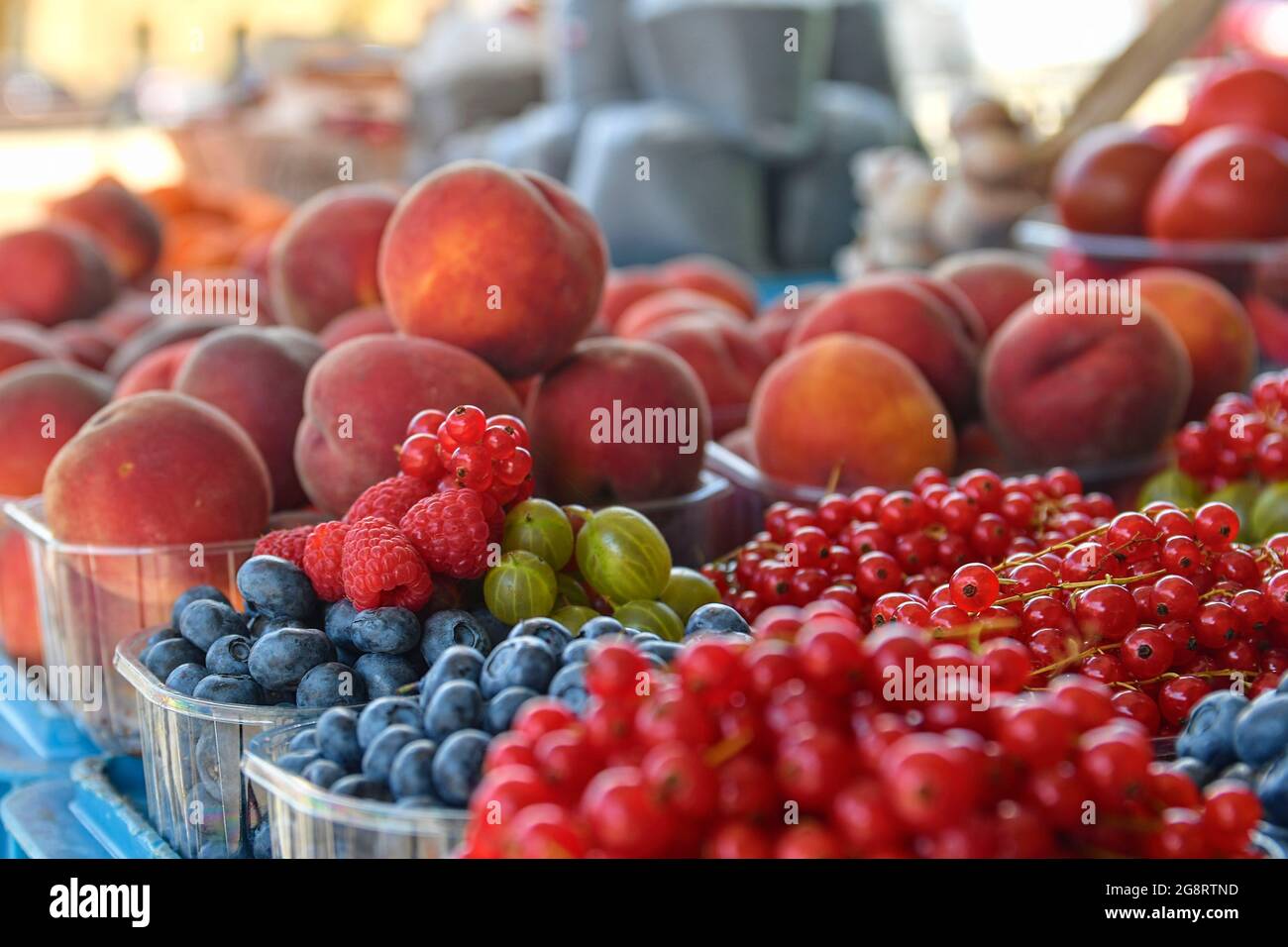 Ribes rosso, lamponi, frutti di bosco, mirtilli, pesche e altri frutti e ortaggi in vendita presso il mercato agricolo locale. Prodotti biologici freschi Foto Stock
