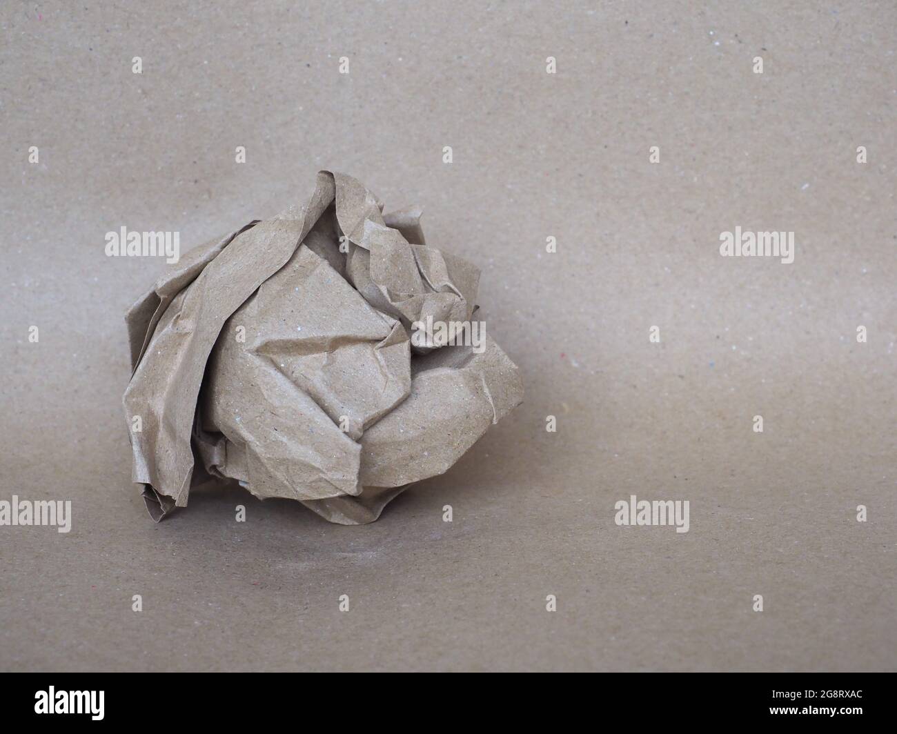 sfera di carta sgualcita su sfondo di carta marrone Foto Stock