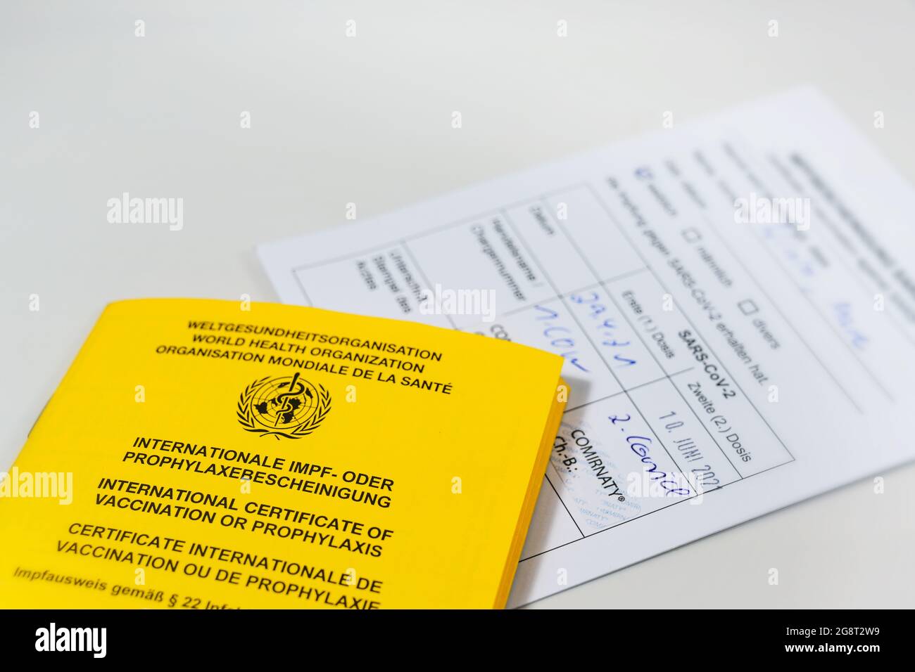 Certificato internazionale giallo di vaccinazione e scheda di registrazione bianca per l'immunizzazione con coronavirus SARS-COV-2 Covid-19 con mRNA covid-19 Vac Biontech Foto Stock