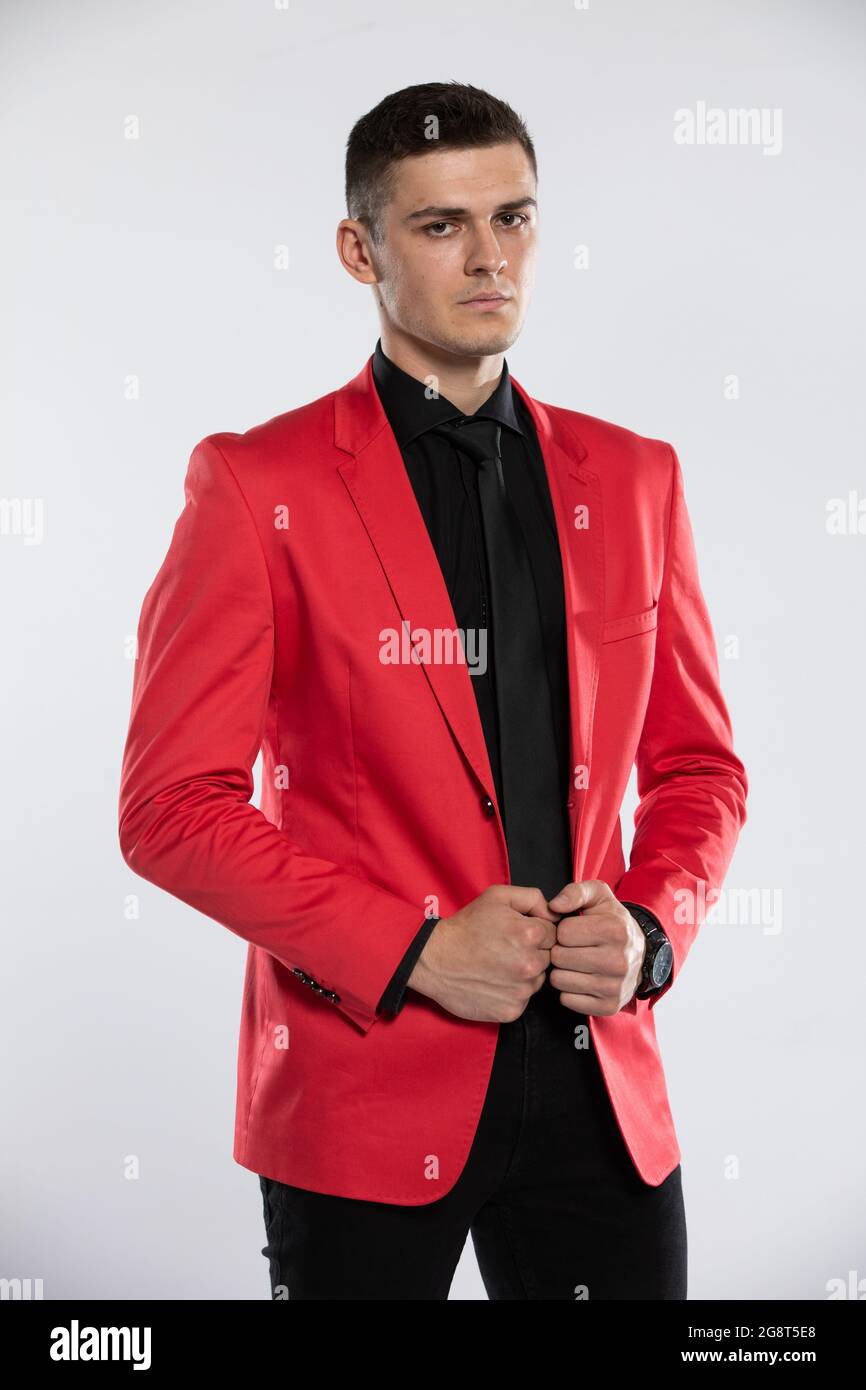 Un giovane ed elegante uomo in giacca rossa e camicia nera. Un