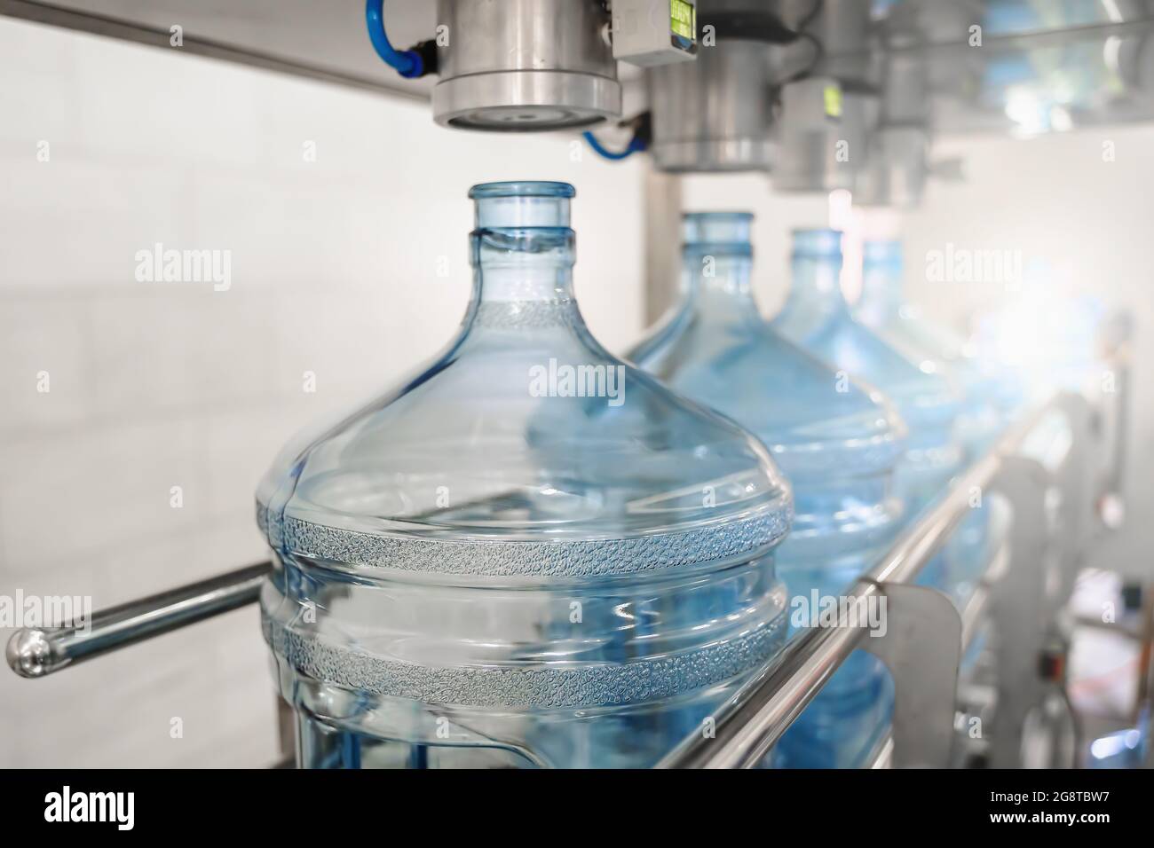 Processo di produzione produzione di acqua potabile depurata e confezionamento in bottiglie di plastica in fabbrica di bevande, industria alimentare, nastro trasportatore. Foto Stock