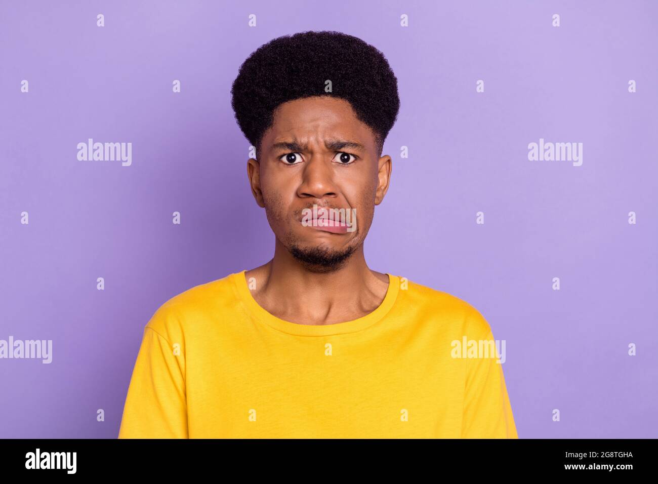 Ritratto di attraente moody confuso guy cattivo umore grimacing isolato su sfondo viola di colore viola Foto Stock