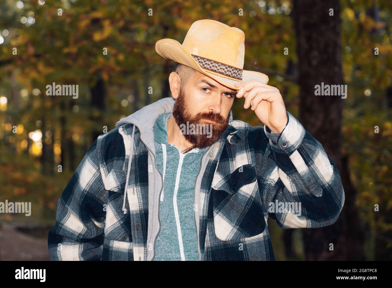 Uomo bearded con cappello cowboy sul parco autunnale e guardando la  macchina fotografica. Attraente giovane uomo in abiti di stagione con  foglia d'oro. I grandi sconti per a Foto stock - Alamy