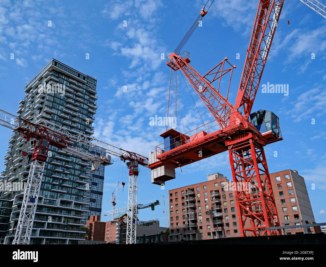 cantiere con gru multiple per la costruzione di un nuovo alto edificio di appartamenti Foto Stock