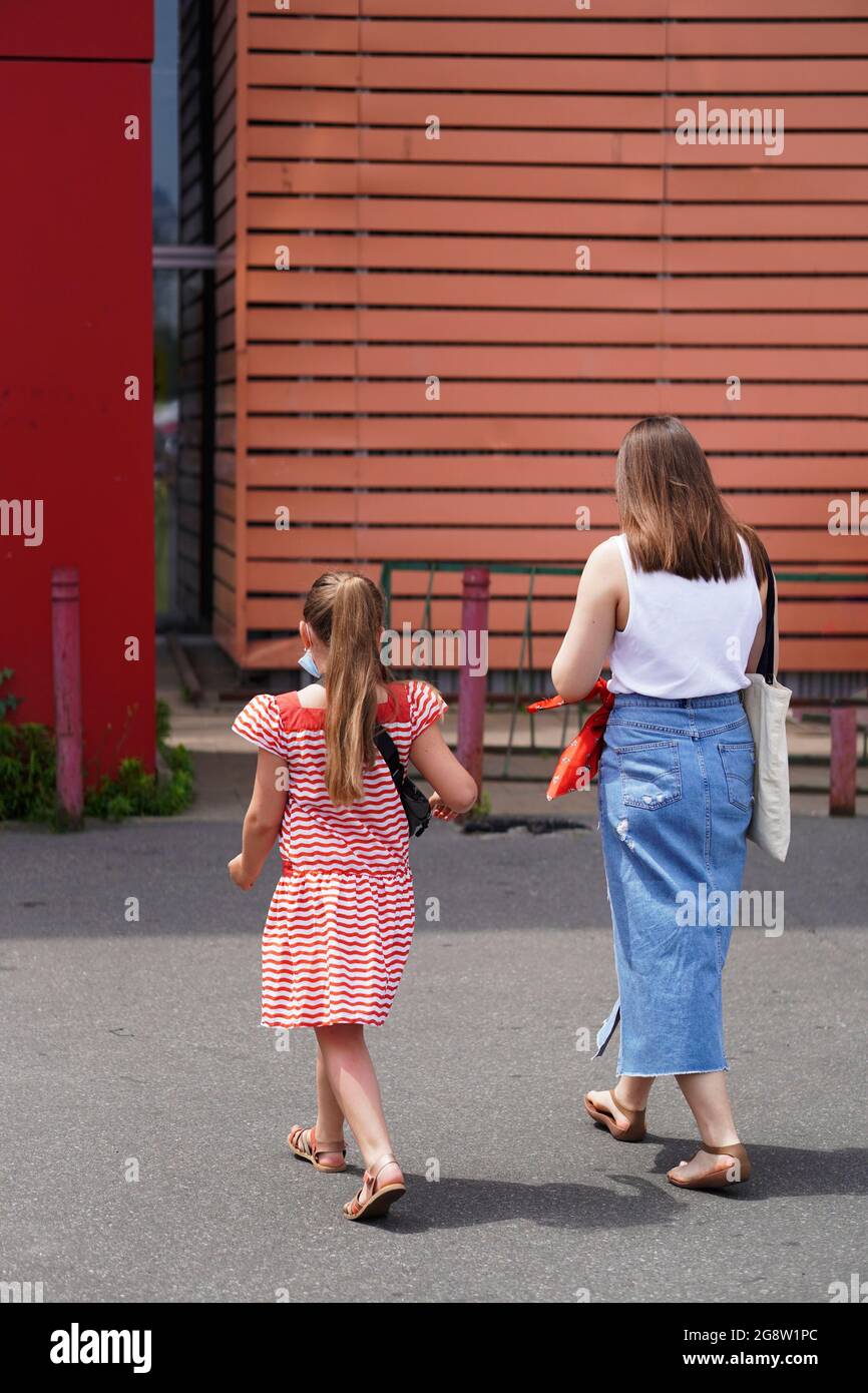 La ragazza della scuola e la sorella più anziana vanno al negozio di abbigliamento al dettaglio. Concetto di ritorno a scuola. Le sorelle stanno andando comprare i rifornimenti della scuola che si preparano a g Foto Stock