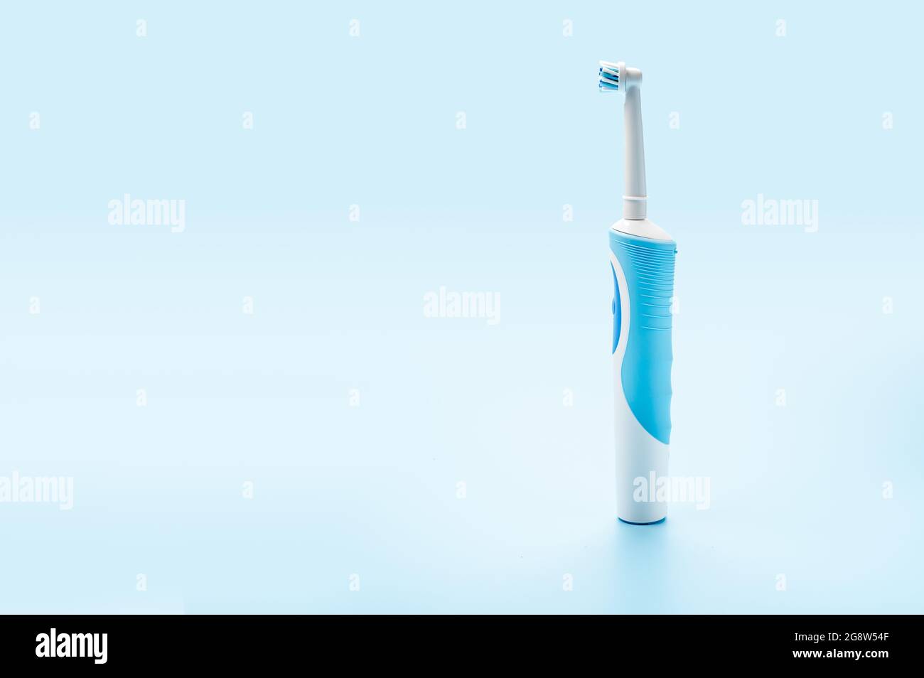 moderno spazzolino elettrico su sfondo blu. Strumenti di cura dentale. Concetto di buona igiene della bocca. Concetto di cura orale professionale e denti sani b Foto Stock