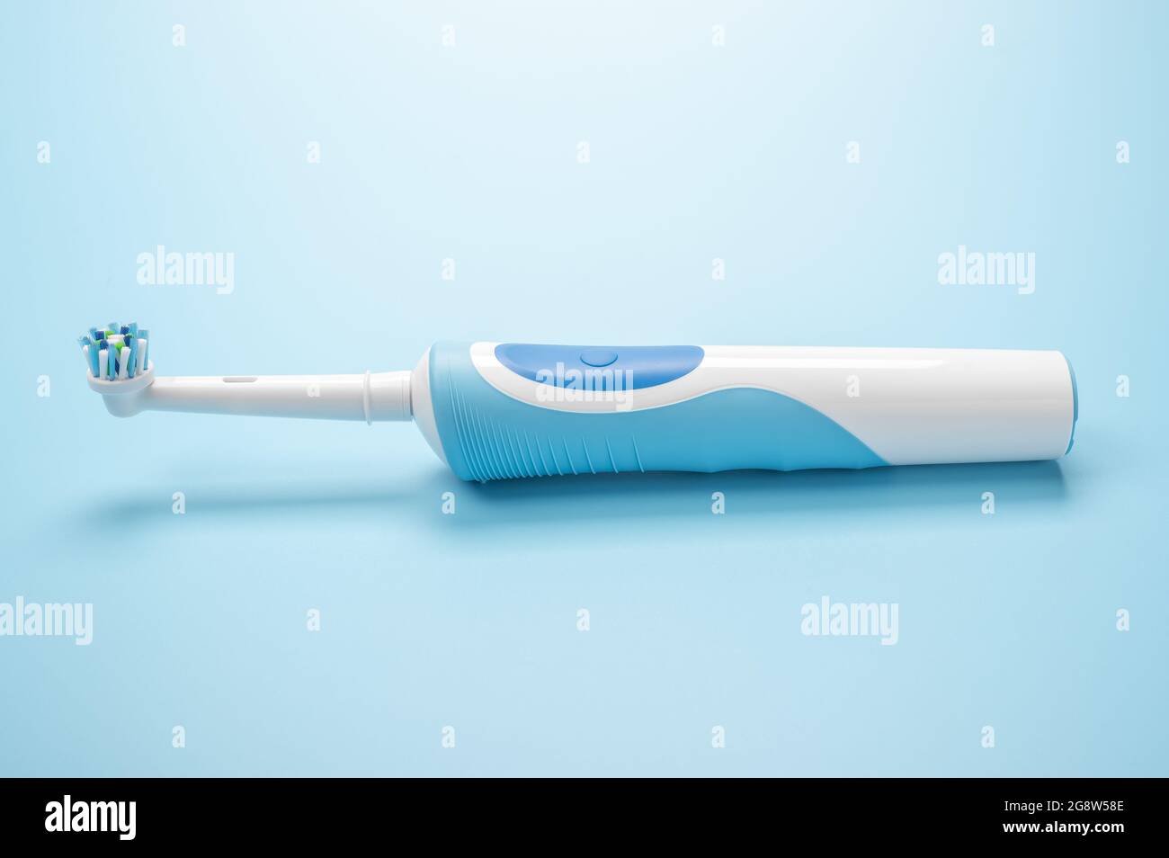 lo spazzolino elettrico moderno si trova su sfondo blu. Strumenti di cura dentale su sfondo bianco. Concetto di buona igiene della bocca. Spazzolino elettrico, close-u Foto Stock